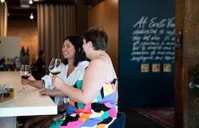Two people holding glasses of wine.
