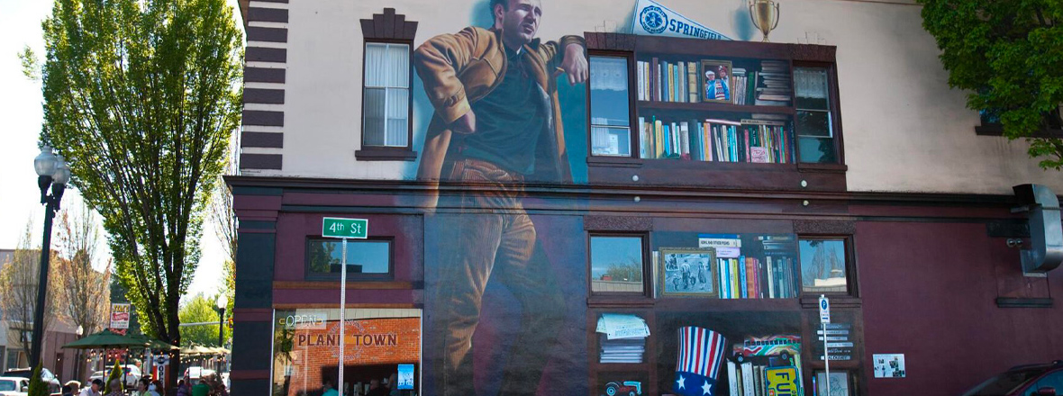 A two-story mural of Ken Kesey on the side of a building.
