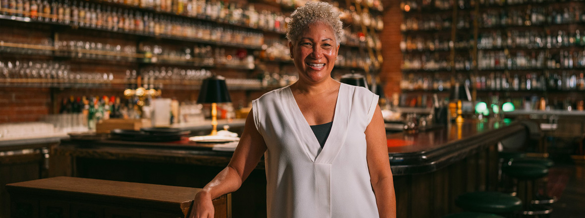 A person stands in front of bar.