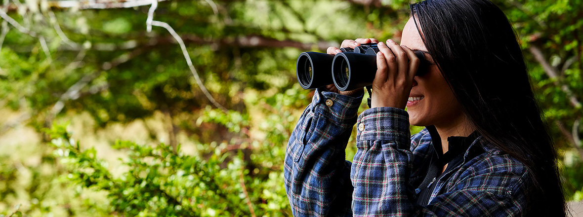 A woman looking through a pair of binoculars.