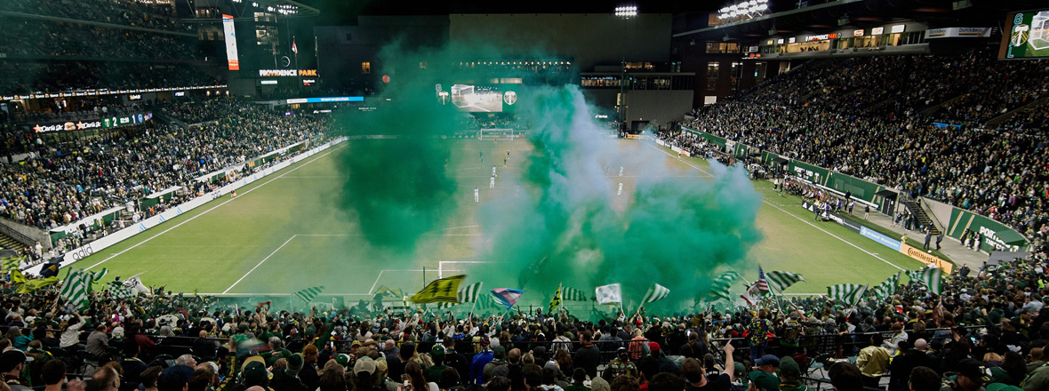 A soccer stadium filled with fans cheering on the Portland Timbers.