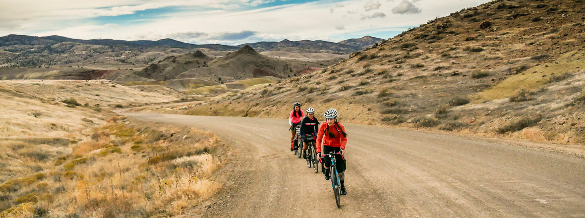 A group of cyclists on a gravel road.