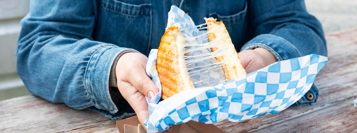 A person pulling apart a grilled cheese.