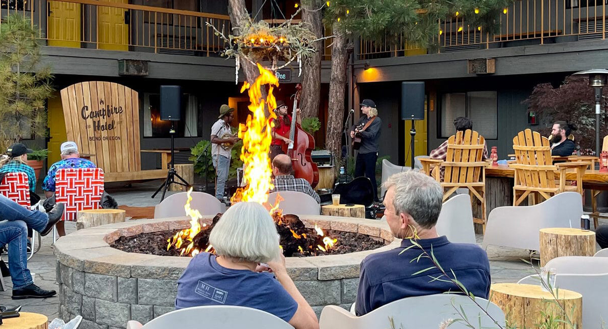 People gathered around a fire pit outside the Campfire Hotel.