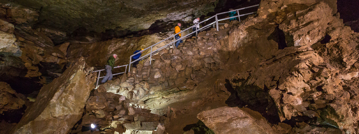 People climbing stairs inside a cave formation.