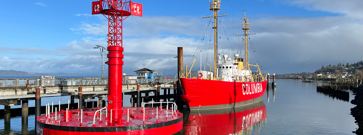 A large red ship docked in a river.
