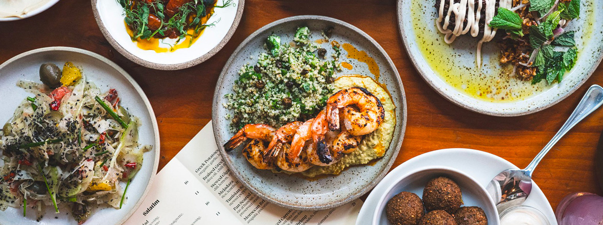Several plates of Mediterranean style foods on a table.
