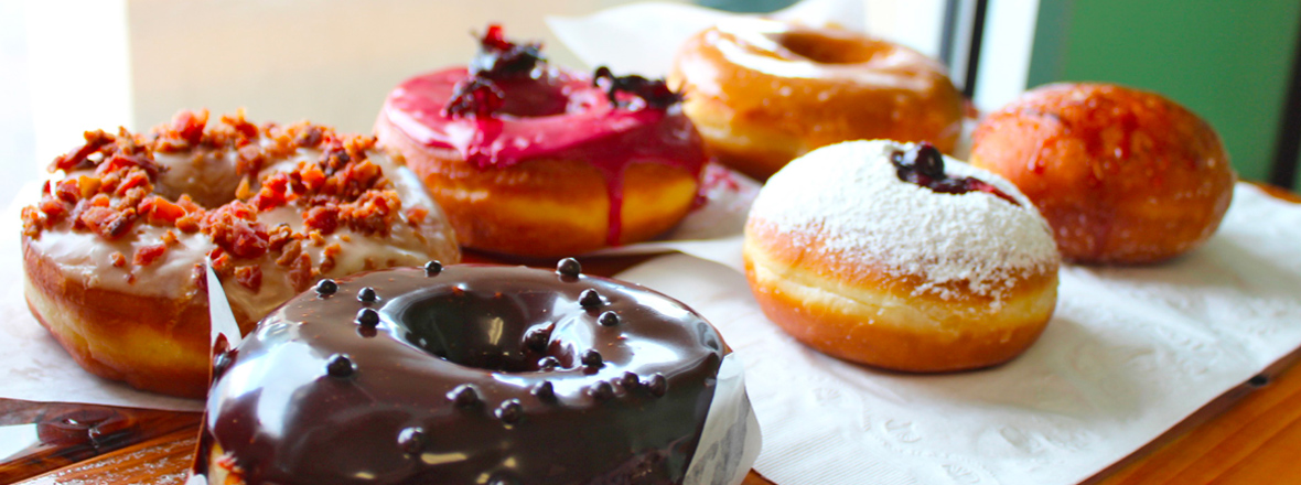 An array of donuts, from chocolate covered to maple bacon, jelly-filled with powder sugar and other flavors.