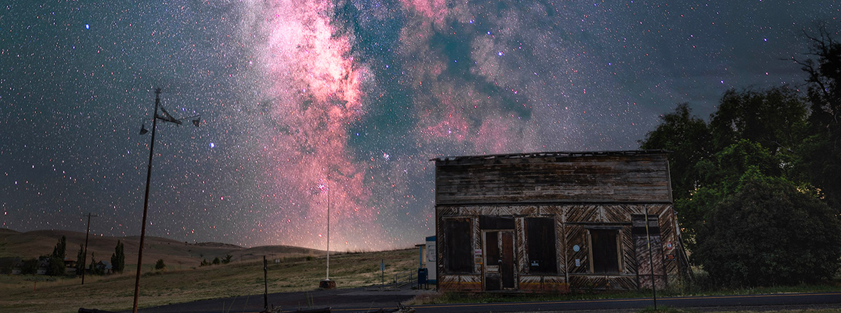 An old wooden building against a backdrop of millions of stars in the night sky.