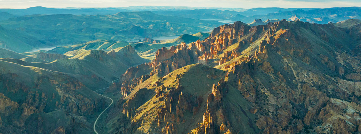Aerial view of a curving road winding through the red rock canyons of Leslie Gulch.