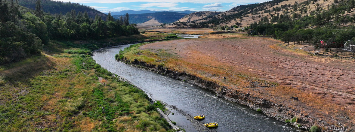 An aerial view of rafts on a river with wide banks.