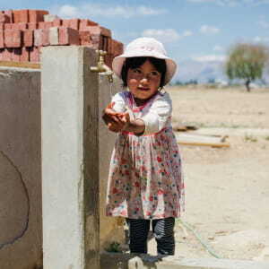 Little girl getting fresh clean water from faucet