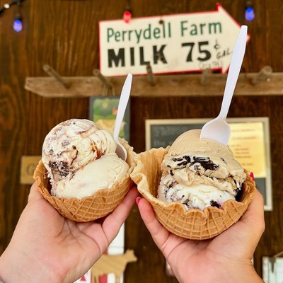 Two ice cream waffles bowls in front of creamery sign