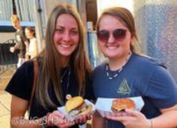 Two teenage girls holding hamburgers