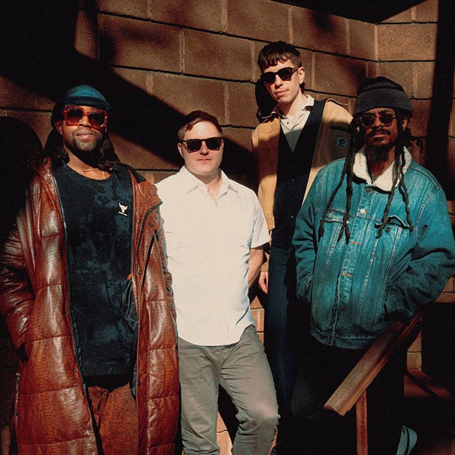 The band Being and Becoming standing together and posing.