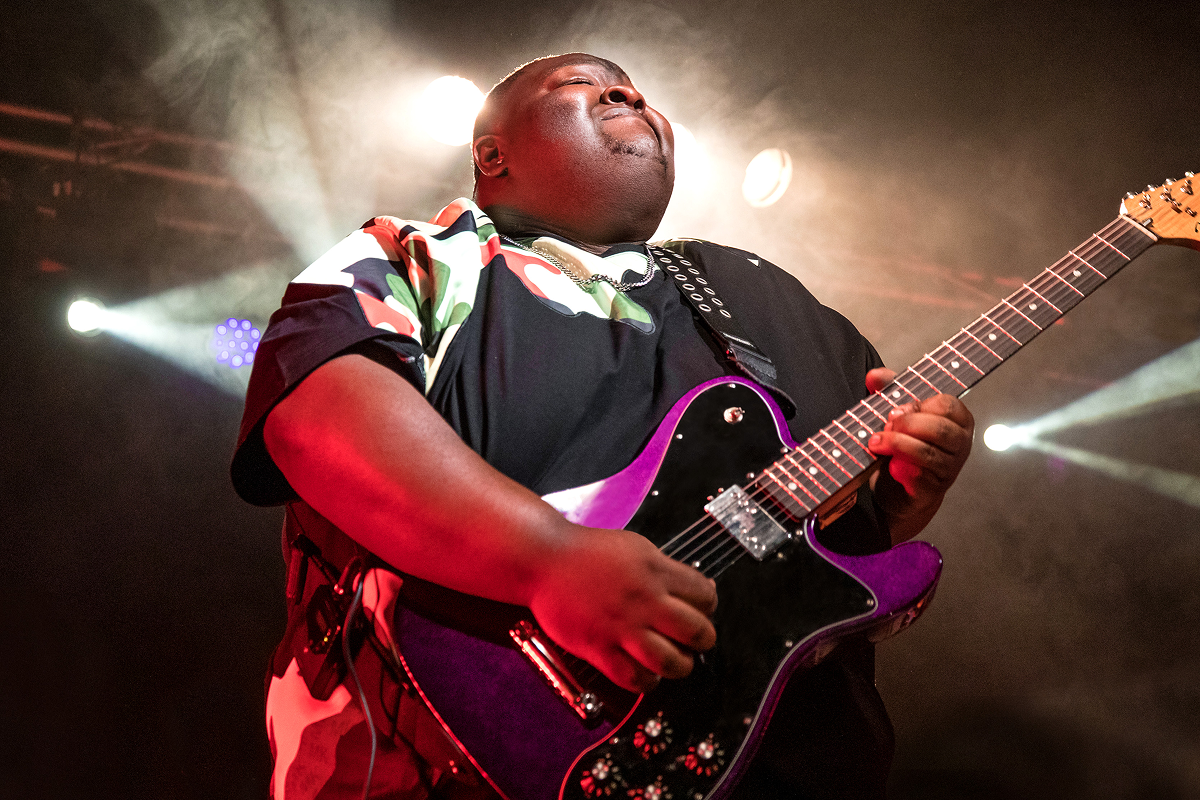 Christone Kingfish Ingram playing the guitar on stage.
