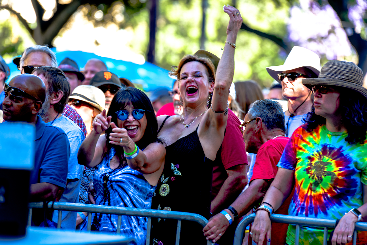 Concertgoers dancing and posing at Fountain City Blues and Brews in the daytime.