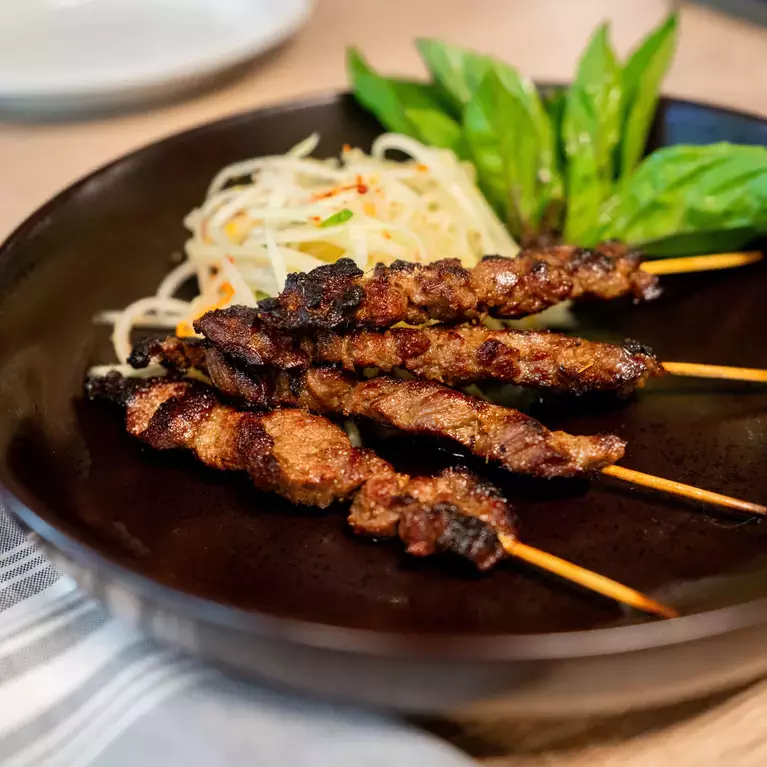 A plated dish with skewered meat and a vegetable at Angkor Chef in San Jose.