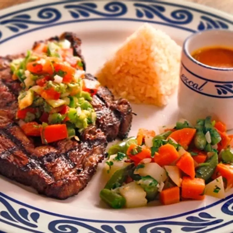 A plated dish with cooked meat, mixed vegetables and rice at Mezcal Restaurant in San Jose.