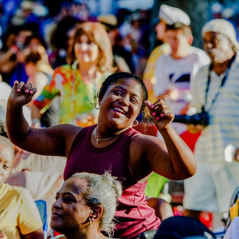 A woman dancing in the crowd at San Jose Jazz Summer Fest in the daytime.