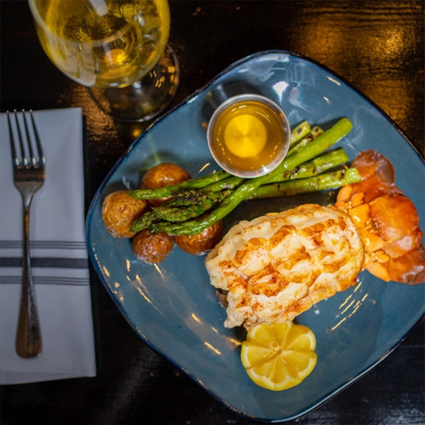 A dinner entree of lobster tail, hushpuppies and asparagus from Scott's Seafood.