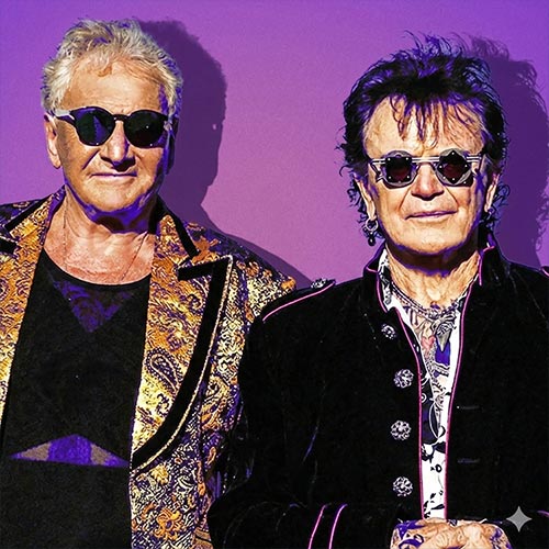Air Supply duo wearing sunglasses against a purple backdrop.