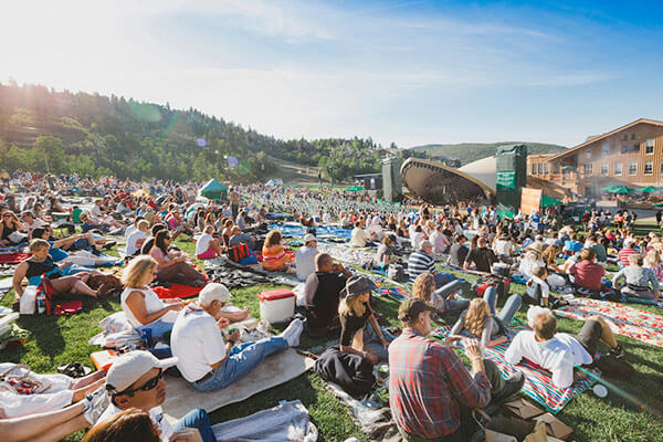 a crowd of people sitting on the lawn at deer valley music festival