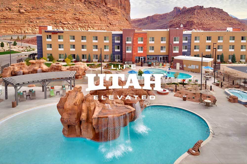 a hotel's outdoor pool with a waterfall in the middle
