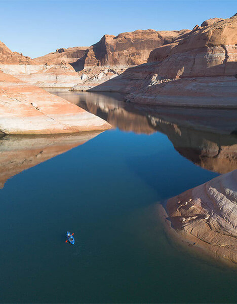 a person kayaking in the water in a canyon