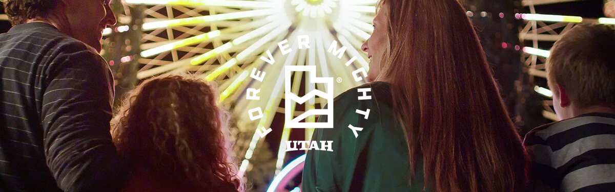 a family looking up at a lit-up ferris wheel