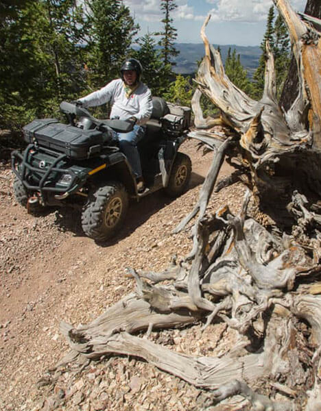 a man riding an atv on a dirt trail