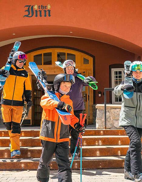 a group of people standing on the steps holding skis