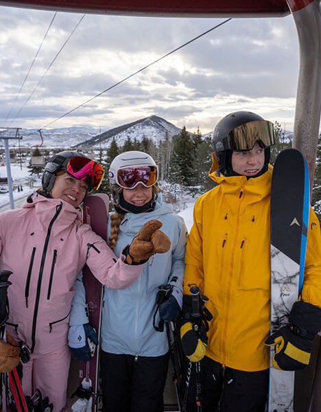 a group of three people standing in a ski gondola