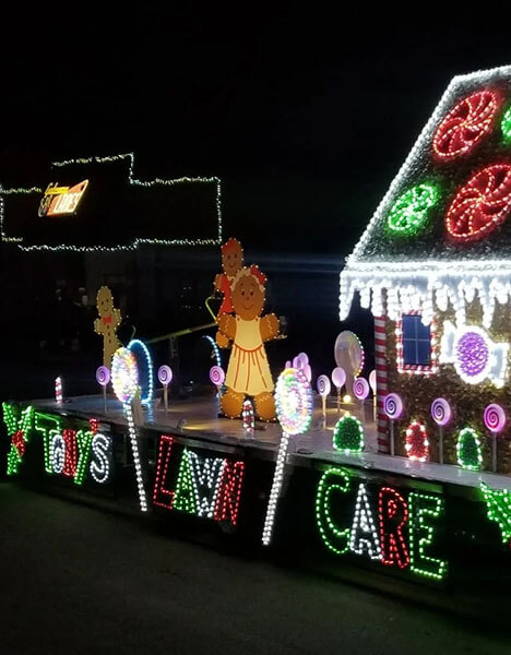 a parade float of a gingerbread house covered in christmas lights