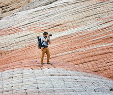 a man taking a picture of rock formations with a camera
