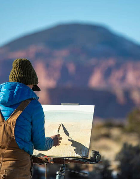 a person painting a picture of a mountain