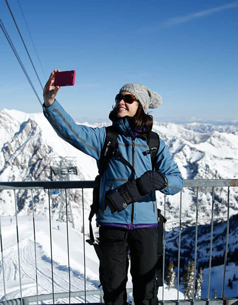 a woman taking a selfie at the top of a chair lift