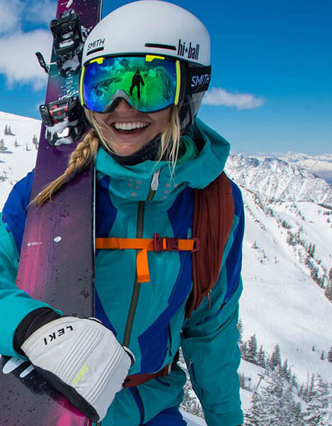 a woman holding a ski on top of a mountain