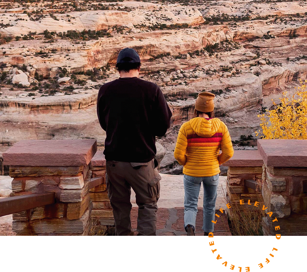 a man and a woman standing on the edge of a staircase leading to rocky terrain