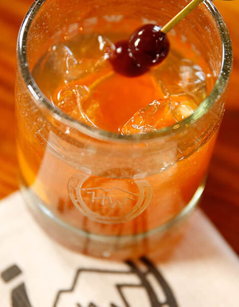 a close up shot of an orange colored cocktail