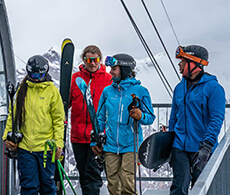 a group of skiers and snowboarders walking on a ski lift