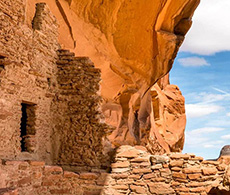 an old stone building with a rock formation on top of it