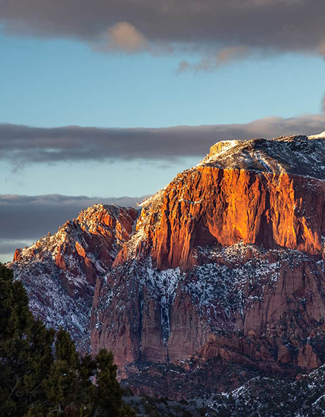 a mountain covered in snow at sunset