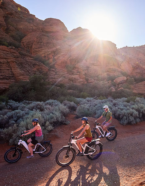 a group of people riding bikes on a dirt road