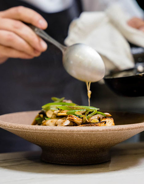A person plating a dish.