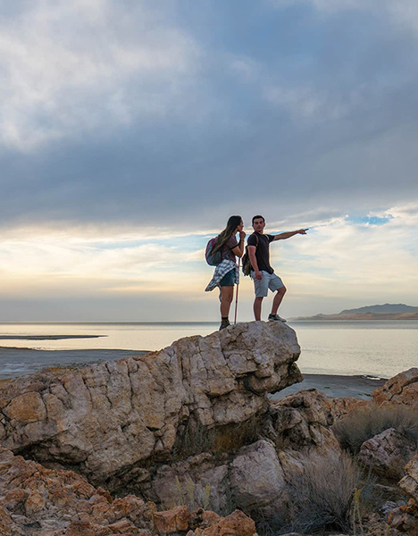A man and a woman standing on the edge of a cliff.