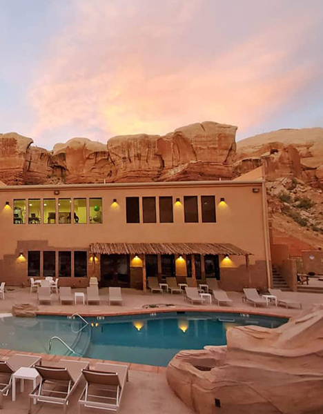 A resort's pool with pool chair all around it.