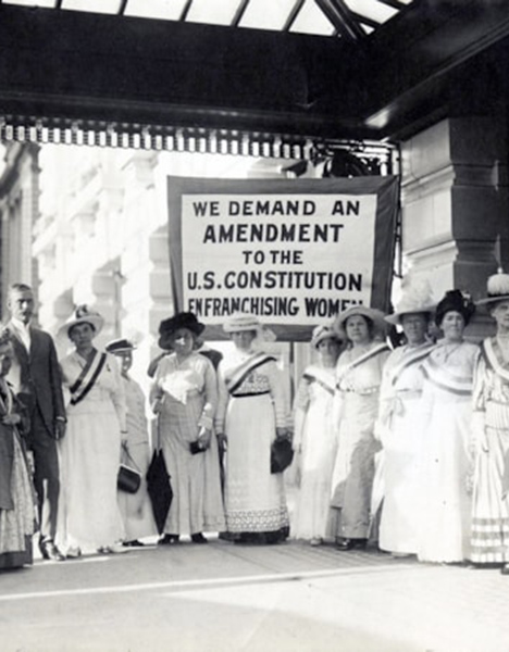 A black and white image of a groupe of women and a man protesting.