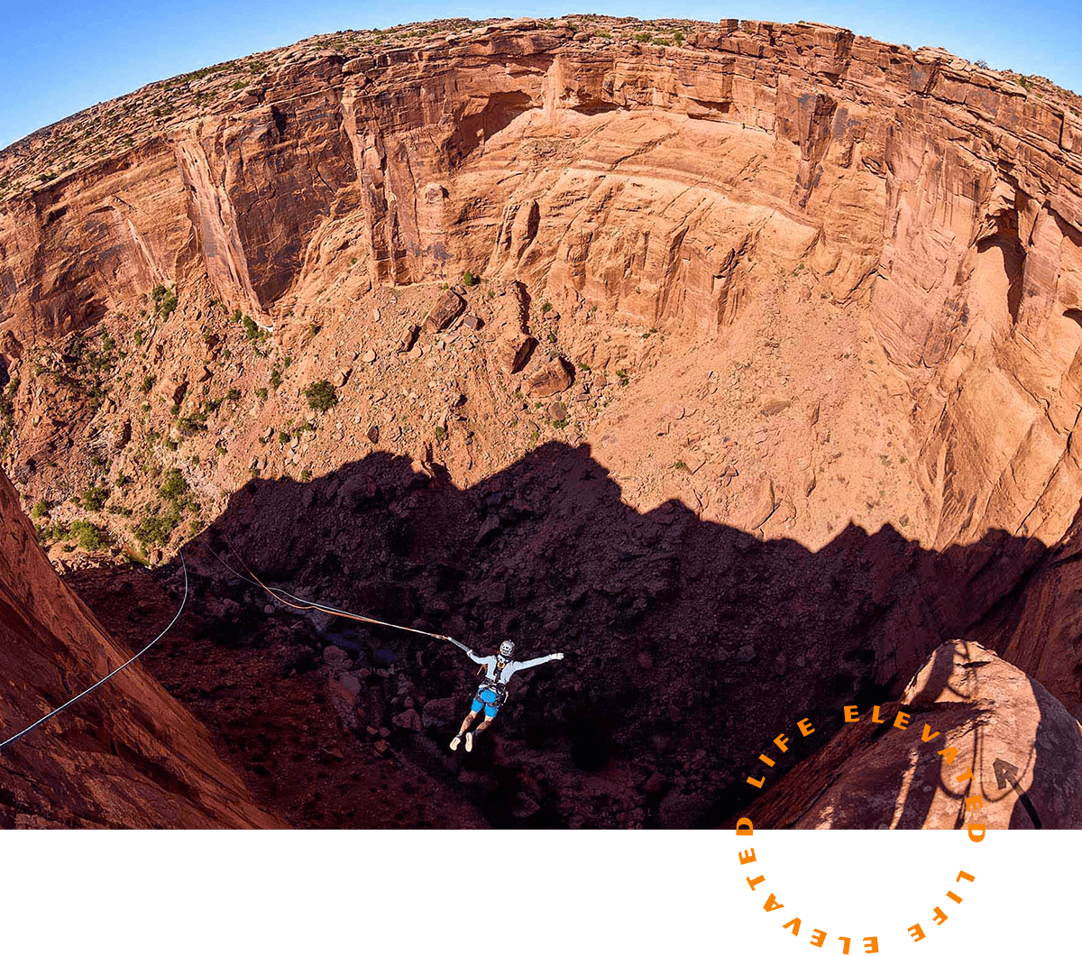 A picture of a person jumping off a cliff with a rope swing attached