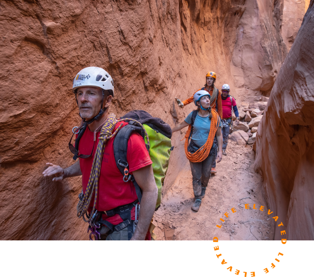 a group of people hiking through a narrow canyon